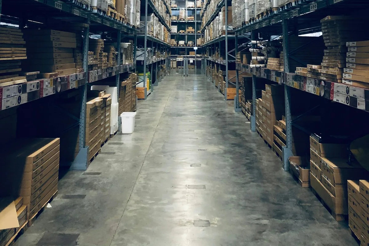 Warehouse aisle lined with boxed inventory on industrial racking